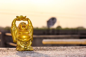 Laughing Buddha. God of Hotei. Gold figurine. Buddhism.