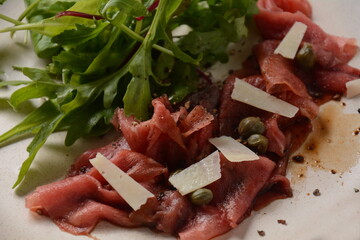 Beef Carpaccio  with parmesan, capers and arugula. With olive oil and soy sauce