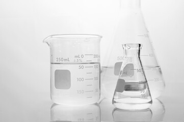 Wall Mural - clear water in beaker and flask in white science laboratory background