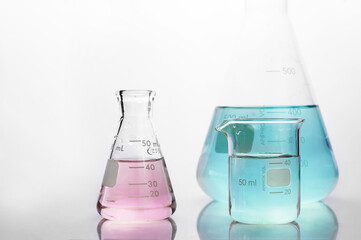 Wall Mural - pink andpink and blue solution in beaker and flask in white science laboratory background