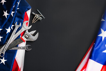 Labor day concept, Top view flat lay of different kinds wrenches with American flag on black. First Monday in September, creation of labor movement and dedicated to social of the American worker