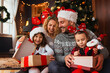 © Tijana - Family of four celebrating Christmas, exchanging presents
