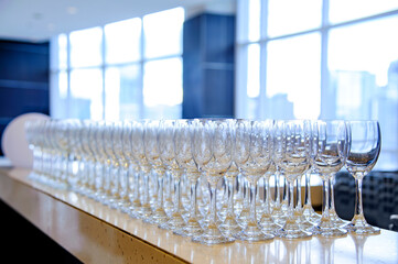 many empty wine glasses line up waiting for pouring some liquor for many invitation guest in dinner reception celebration party in a lounge in the hotel