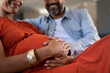 © Rido - Future father feeling baby bump of pregnant woman