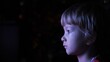 © MEDIAIMAG - Portrait of child connected at TV, light in black night, modern education