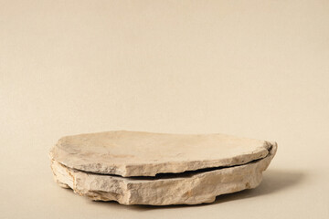 Background for cosmetic products of natural beige color. Stone podium on a white background. Front view.