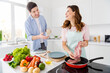 © deagreez - Two people dream harmony married couple enjoy hobby cooking girl fry raw organic meat pan communicate with husband hold cup coffee tea in kitchen house indoors weekend