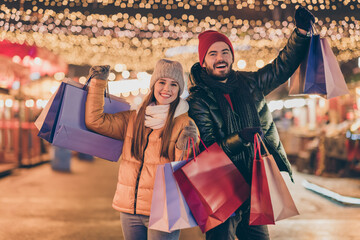 Poster - Black friday. Photo of two people students friends raise buy shopping bags under outside x-mas christmas time evening illumination