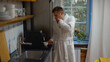 © nimito - Young man in bathrobe making coffee and yawning in kitchen early in morning