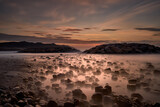 Fototapeta Miasto - Landscape of a sunrise on the beach with rocks