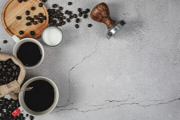 A cup of coffee and coffee beans on white, marble background