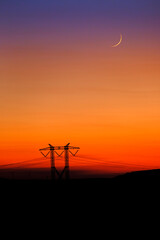 Sunset and Moon with Power Lines on Horizon