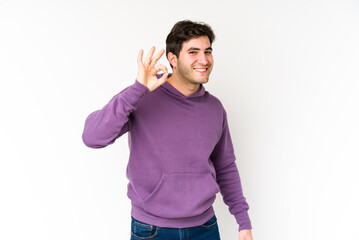 Young man isolated on white background cheerful and confident showing ok gesture.