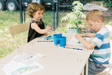 Little Artists Painting With Watercolors Outside On The Patio