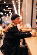 © Alexey Klementiev/Stocksy - young woman in total black sitting in cafe