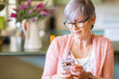 © Clare Seibel-Barnes/Austockphoto - Older woman texting on mobile phone inside home