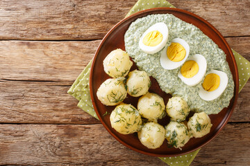 Frankfurt traditional dish of potatoes, boiled eggs and the famous green sauce close-up on a plate on the table. horizontal top view from above