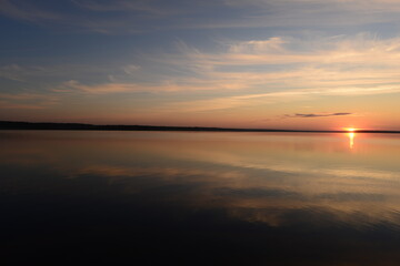 Wall Mural - Sunbeam at sunset on the blue calm water of the lake