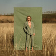 Fashion shooting. The girl in the suit. Fabric background and nature