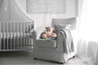 © New Africa - Baby room interior with comfortable crib and armchair