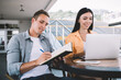 © BullRun - Casual colleagues using laptop and notebook in outdoor cafe