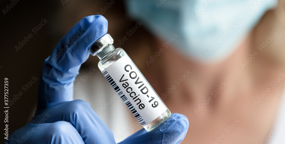 COVID-19 vaccine concept, female doctor holds coronavirus medication in office or laboratory - obrazy, fototapety, plakaty 