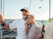 © Artem Varnitsin - Affectionate senior couple embracing on yacht and looking into the distance. Retired couple standing together on sailboat.