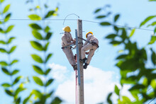 Electrical Experts Are On The Power Poles To Install Steel Brackets For Power Lines.