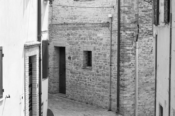 Wall Mural - Alley of an Italian village with old brick houses, plants and flowers (Fiorenzuola di Focara, Italy, Europe)