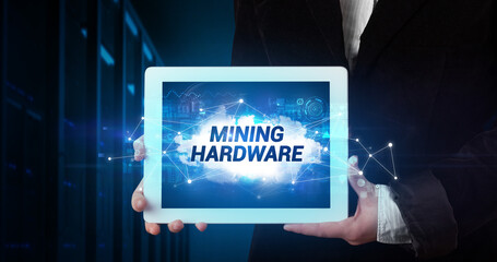 Young business person working on tablet and shows the inscription: MINING HARDWARE