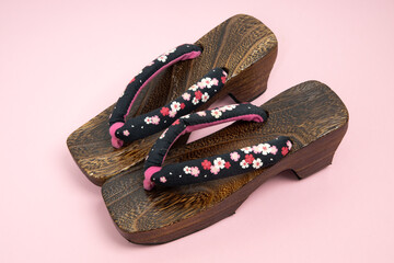 japanese traditional geta sandal on pink background. traditional japanese asian wood footwear called