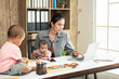 © sutlafk - Busy asian woman trying to work while baby sitting two kids. Single mom work from home with the children.