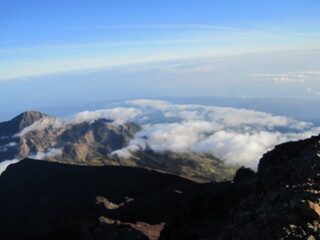 Picturesque volcano mountain filled with clouds. Trekking route to the rocky summit of Mount Rinjani in Lombok Island, Indonesia.