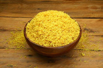 Indian Snacks besan sev or nylon sev or barik sev in wooden bowl.