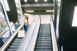 © Harry Rendón - young tourist with face mask uses subway escalator