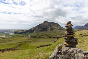 stones in front of a green landscape with a mountain in the distance