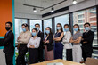 © nikomsolftwaer - Young people with face masks at work in office. Group of bussiness with face masks looking at camera, corona virus concept.