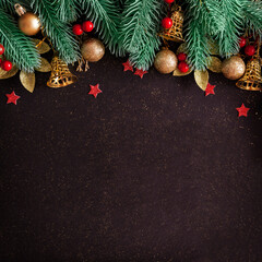 Wall Mural - christmas layout with pine tree, gold baubles and bells, red stars on black background with copy spa