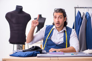 Young male tailor working at workshop