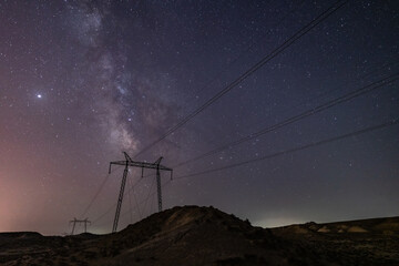 Wall Mural - milky way galaxy in the night sky above power line supports