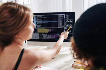 teenagers studying programming at home and discussing generated chart on computer screen, view from 