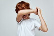redhead boy covers hand over face white t-shirt cropped view studio 