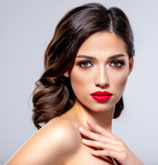 Wall Mural - Beautiful young fashion woman with red lipstick.  Brunette woman with a clean skin of face. Portrait of model with bright red lips. Glamour fashion model with bright gloss make-up  posing at studio.