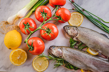 Wall Mural - fresh rainbow fish trout on black stone background with vegetables 