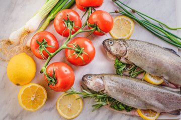 Wall Mural - fresh rainbow fish trout on black stone background with vegetables 