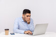 © khosrork - I won't tell anything! Frightened man employee sitting office workplace, covering mouth looking terrified at laptop screen, talking video call or found scary secret on internet. studio shot isolated