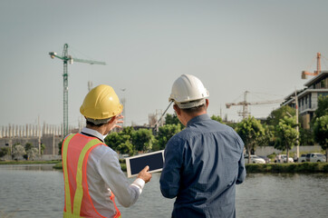 Engineers discuss site planning and analyze building construction.