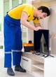 © Elnur - Male professional serviceman repairing tv at home