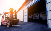 The Big Industrial Forklift Drives Into The Warehouse.