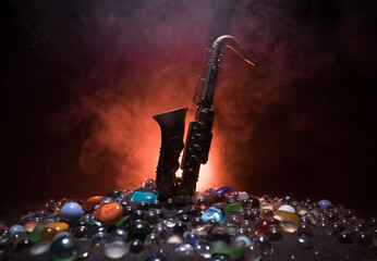 Alto gold sax miniature with colorful toned light on foggy background. Saxophone music instrument in lowlight. Selective focus